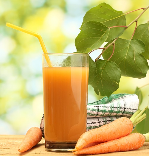glass of carrot juice and fresh carrots